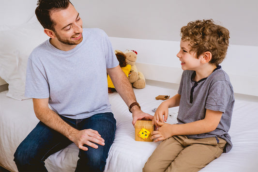 A father and his child sitting on the couch opening a Lovebox.