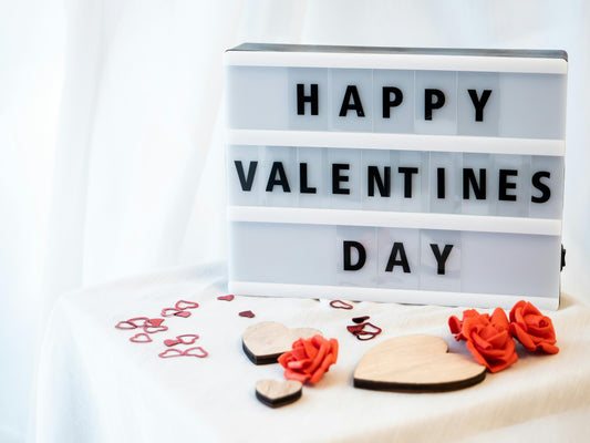 Thoughtful valentine's day gift setup with a wrapped present and a heartfelt message on a phone