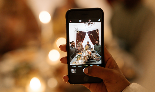 A woman Holding her phone to take a picture of her family