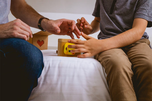 A father and son open a lovebox together they received from mother.