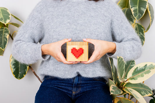 Woman holding a wooden Lovebox with a red heart on it.